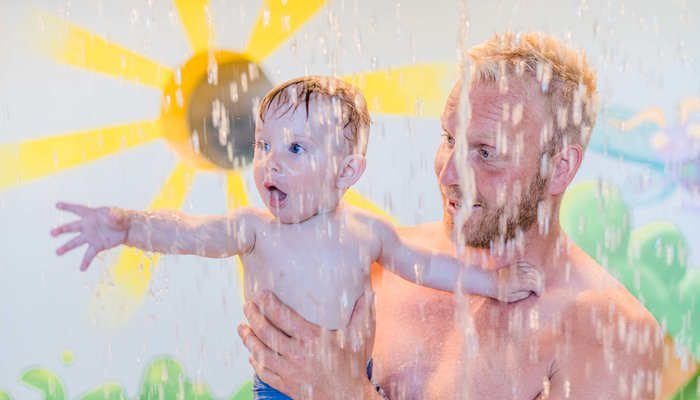 Kind unter Wasserfall